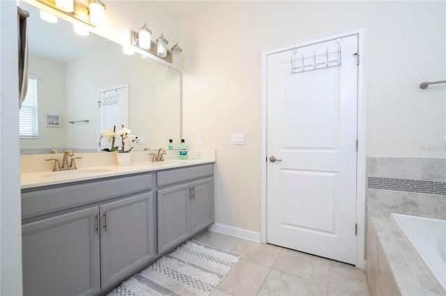 bathroom with tile patterned floors, vanity, and tiled tub