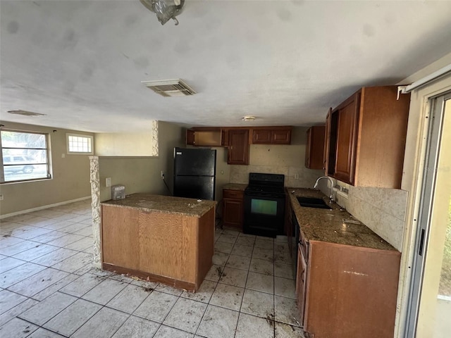 kitchen featuring dark stone counters, tasteful backsplash, sink, and black appliances