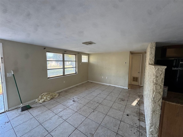 unfurnished room featuring a textured ceiling