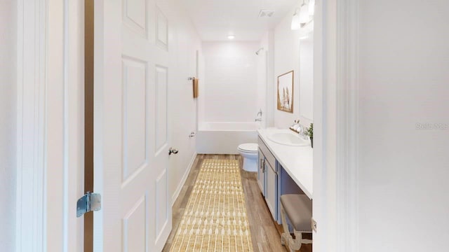 full bathroom featuring shower / tub combination, vanity, wood-type flooring, and toilet