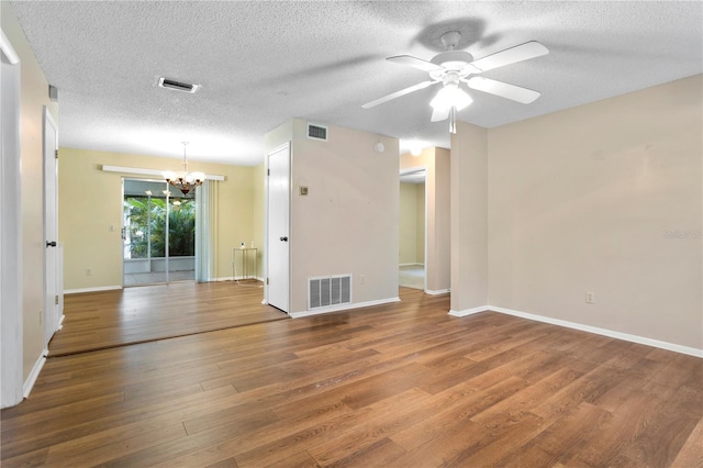 spare room with a textured ceiling, ceiling fan with notable chandelier, and wood-type flooring