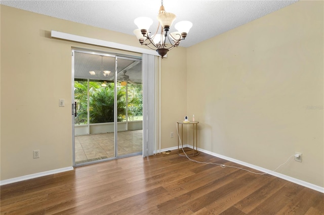 unfurnished room featuring a textured ceiling, ceiling fan with notable chandelier, and wood-type flooring