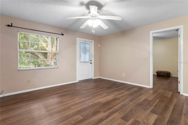 unfurnished room with a textured ceiling, ceiling fan, and dark wood-type flooring