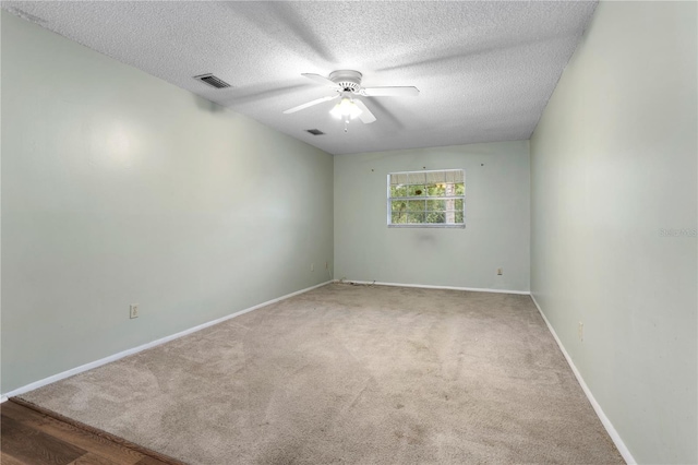 carpeted spare room with a textured ceiling and ceiling fan