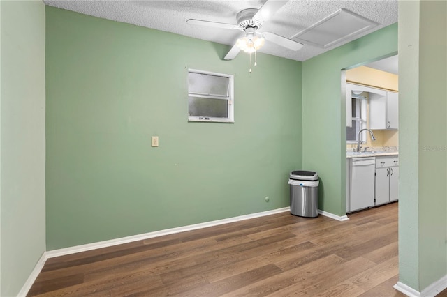 empty room featuring a textured ceiling, ceiling fan, light hardwood / wood-style flooring, and sink