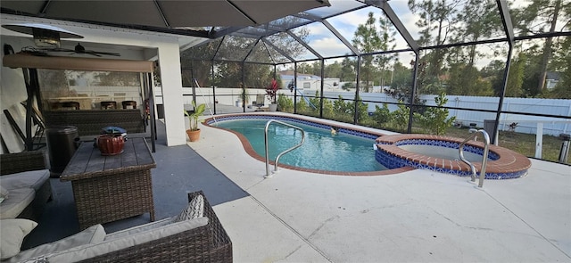 view of pool with a patio area, a pool with connected hot tub, a lanai, and fence