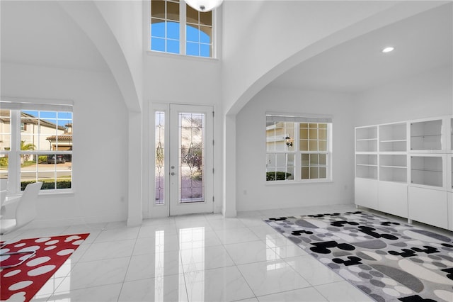 tiled foyer entrance with a towering ceiling