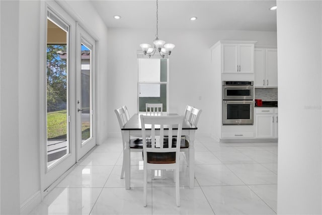 tiled dining area with a wealth of natural light and a notable chandelier