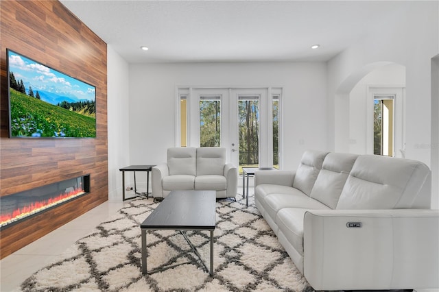 tiled living room with wood walls and french doors