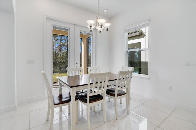 tiled dining area with french doors and a chandelier