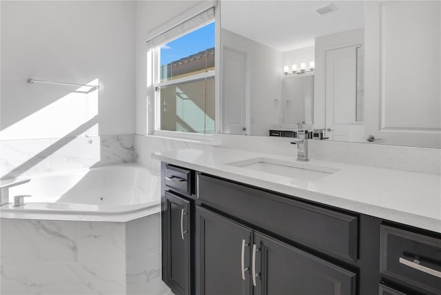 bathroom with a washtub and vanity