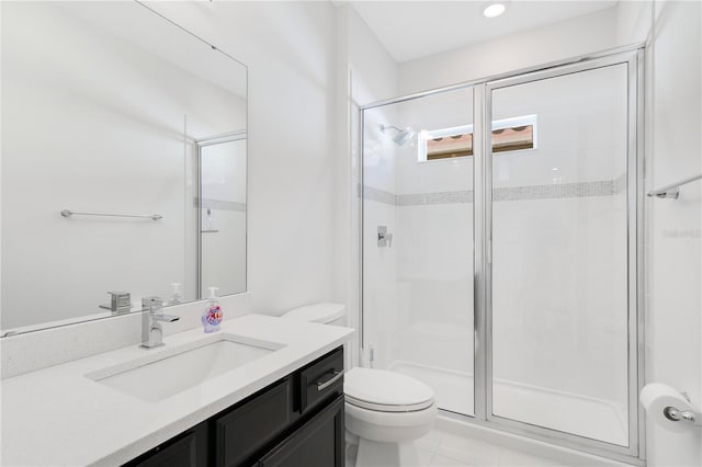 bathroom featuring tile patterned flooring, vanity, toilet, and a shower with door