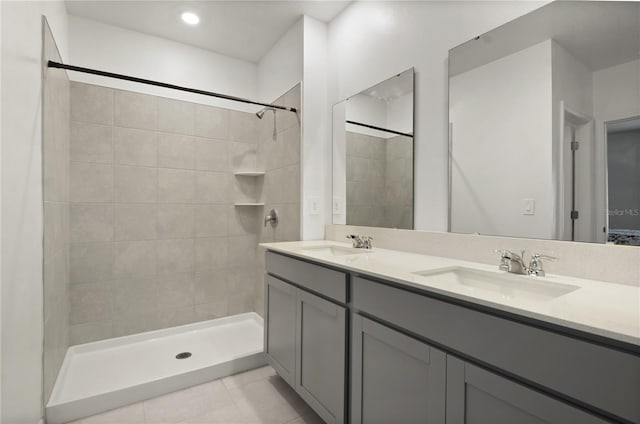 bathroom featuring vanity, tile patterned flooring, and a tile shower