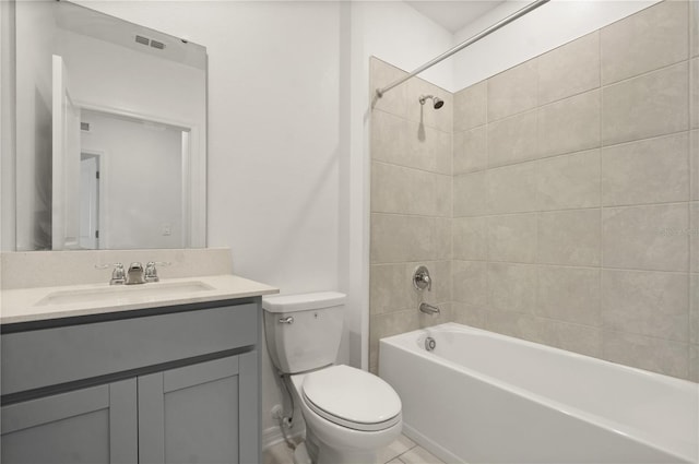 full bathroom with tiled shower / bath, vanity, and toilet