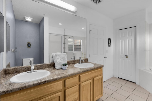 bathroom featuring tile patterned flooring, vanity, toilet, and walk in shower