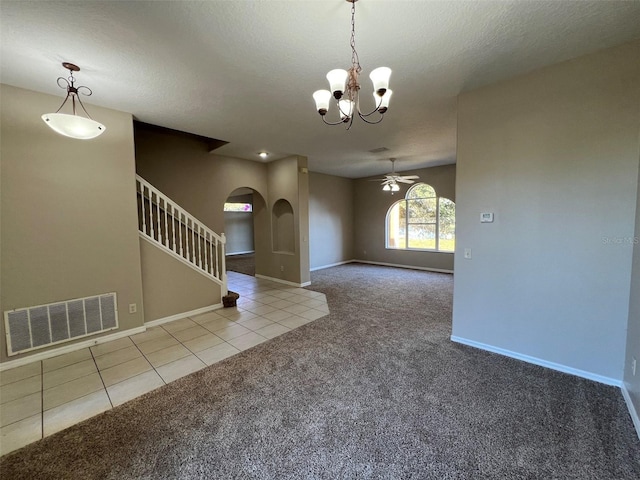 tiled spare room with a textured ceiling and ceiling fan with notable chandelier