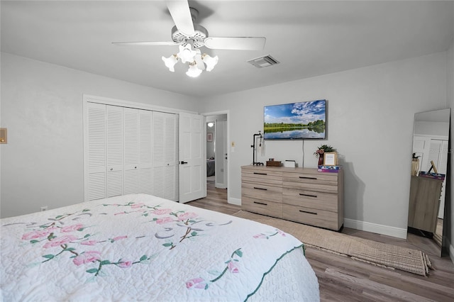 bedroom with ceiling fan, dark wood-type flooring, and a closet