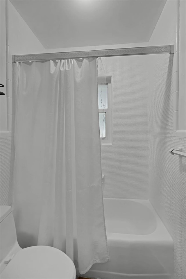 bathroom with shower / tub combo and toilet