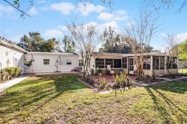 back of house featuring a patio area, a sunroom, and a yard