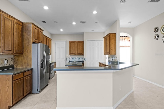 kitchen featuring backsplash, stainless steel appliances, kitchen peninsula, and light tile patterned floors