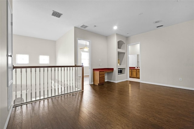 empty room with ceiling fan, a fireplace, and dark hardwood / wood-style floors