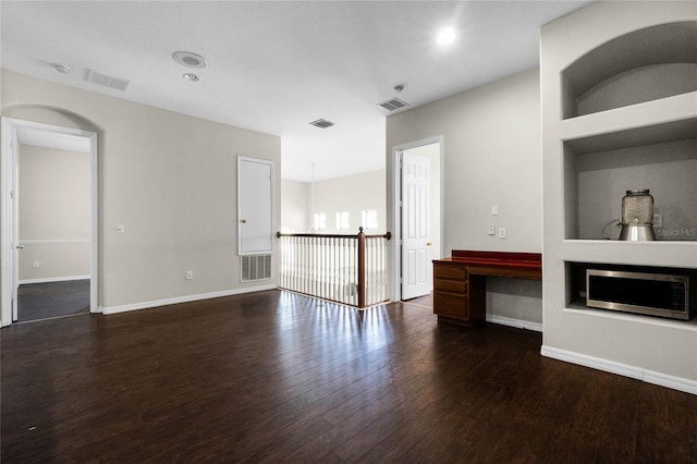 unfurnished living room with built in features, dark hardwood / wood-style flooring, and a fireplace