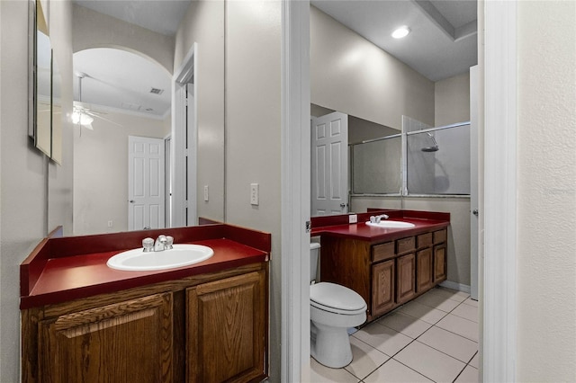 bathroom with ceiling fan, tile patterned flooring, vanity, toilet, and walk in shower