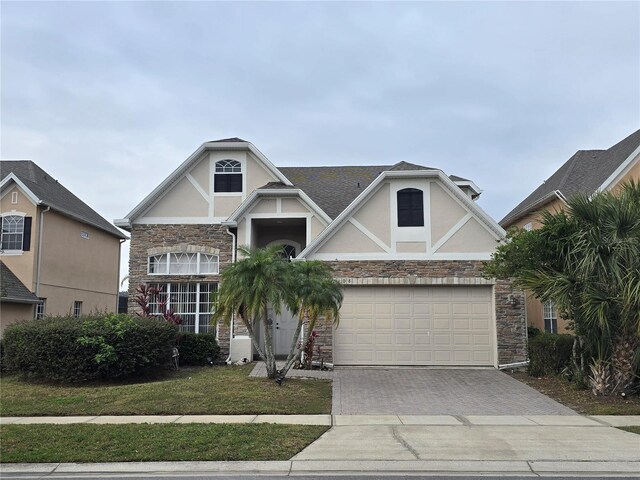 1108 Darnaby Way, Orlando, FL 32824 - craftsman-style home featuring a garage, driveway, stone siding, and stucco siding