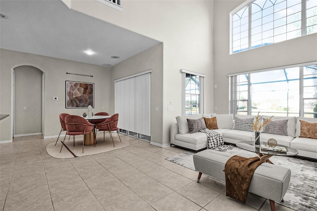 1108 Darnaby Way, Orlando, FL 32824 - living room with light tile patterned floors, arched walkways, and a high ceiling