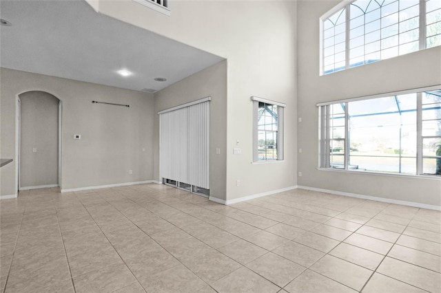 1108 Darnaby Way, Orlando, FL 32824 - interior space featuring light tile patterned flooring, arched walkways, a wealth of natural light, and a towering ceiling