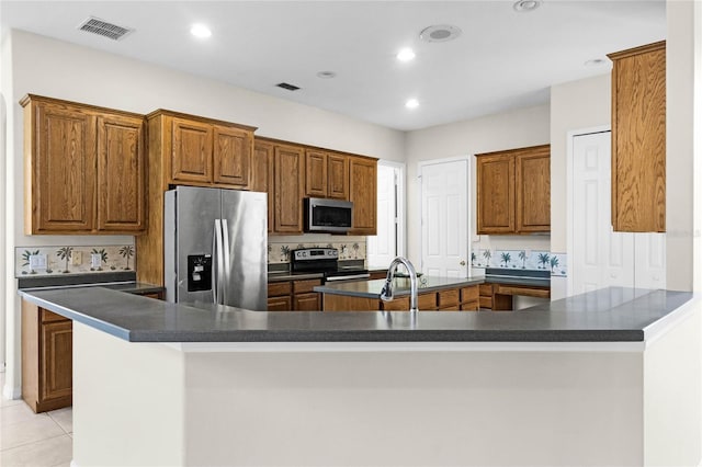 1108 Darnaby Way, Orlando, FL 32824 - kitchen with dark countertops, appliances with stainless steel finishes, brown cabinetry, and visible vents