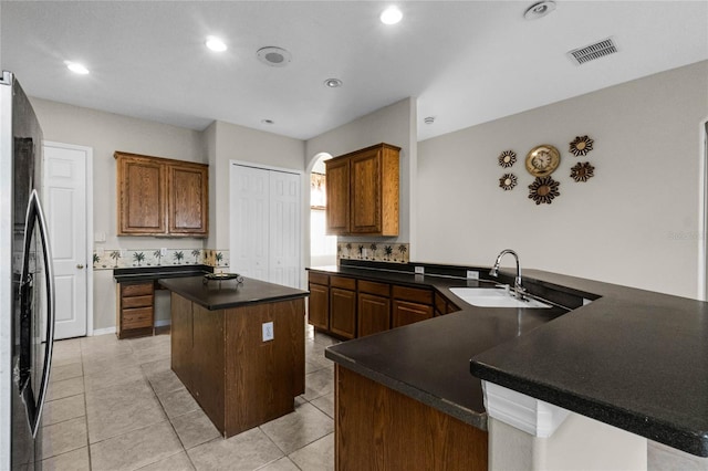 1108 Darnaby Way, Orlando, FL 32824 - kitchen featuring dark countertops, stainless steel refrigerator, a sink, a center island, and visible vents