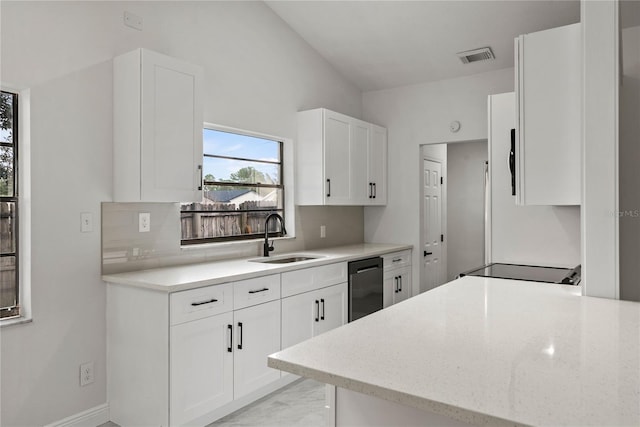 kitchen featuring white cabinetry, sink, dishwasher, backsplash, and vaulted ceiling