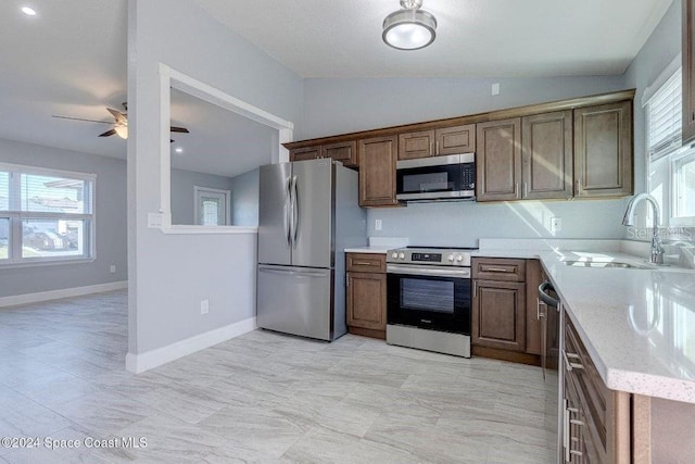 kitchen with lofted ceiling, a healthy amount of sunlight, appliances with stainless steel finishes, and a sink