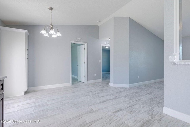 interior space with a notable chandelier, vaulted ceiling, visible vents, and baseboards