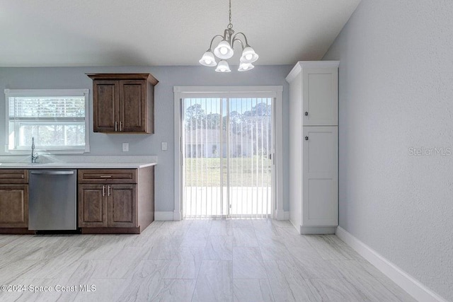 kitchen featuring dishwasher, light countertops, a sink, and a wealth of natural light