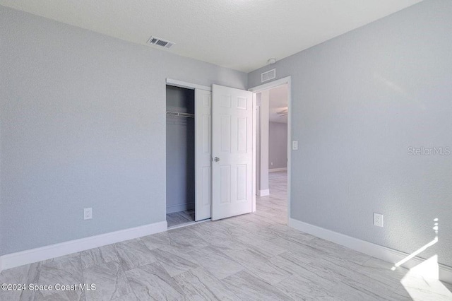 unfurnished bedroom featuring a closet, visible vents, and baseboards