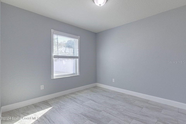 spare room with baseboards