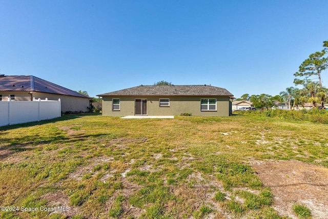 back of house featuring a patio, a lawn, and fence