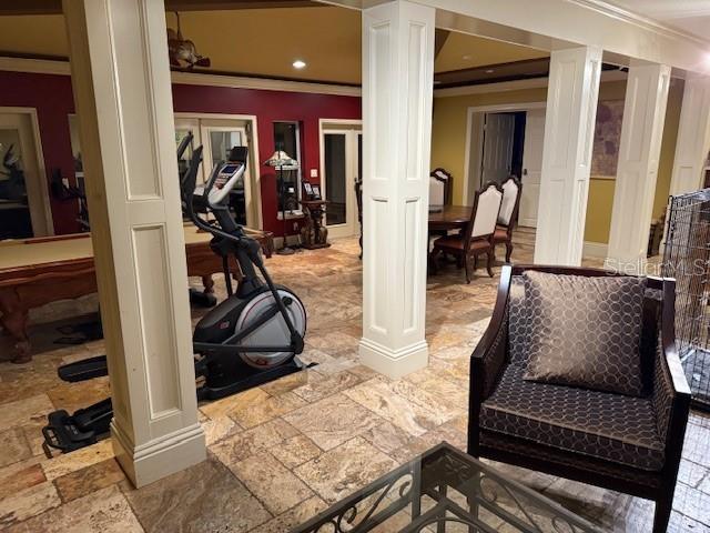 interior space with french doors, decorative columns, and crown molding