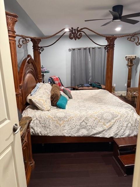 bedroom featuring ceiling fan, dark hardwood / wood-style flooring, and vaulted ceiling