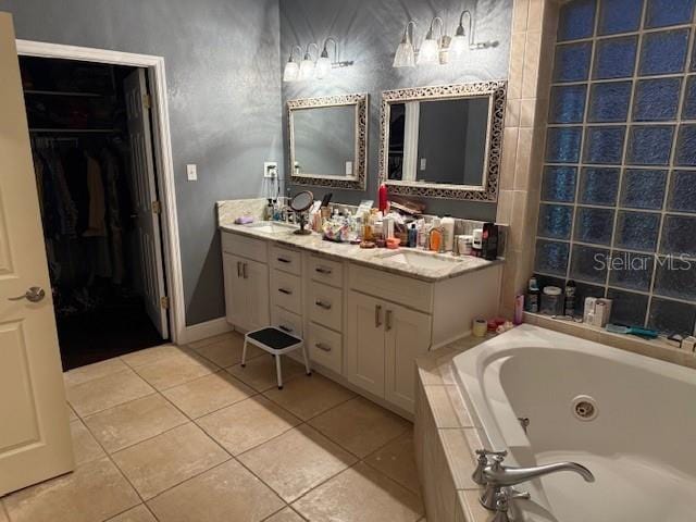 bathroom featuring tile patterned floors, tiled bath, and vanity