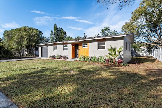 ranch-style home featuring a front lawn and a garage