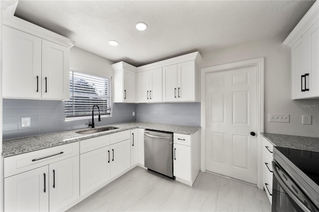 kitchen featuring backsplash, white cabinetry, sink, and stainless steel appliances