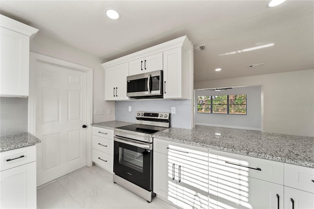 kitchen featuring decorative backsplash, light stone countertops, white cabinetry, and stainless steel appliances