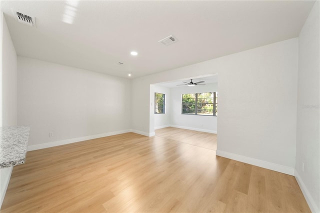 empty room with ceiling fan and light hardwood / wood-style floors