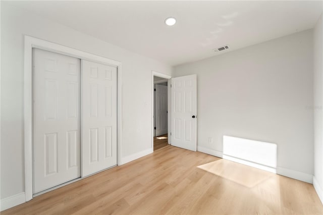 unfurnished bedroom featuring light wood-type flooring and a closet