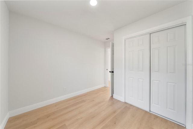 unfurnished bedroom featuring light hardwood / wood-style floors and a closet