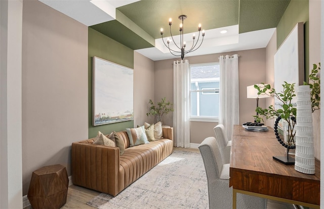 office area with a tray ceiling and an inviting chandelier