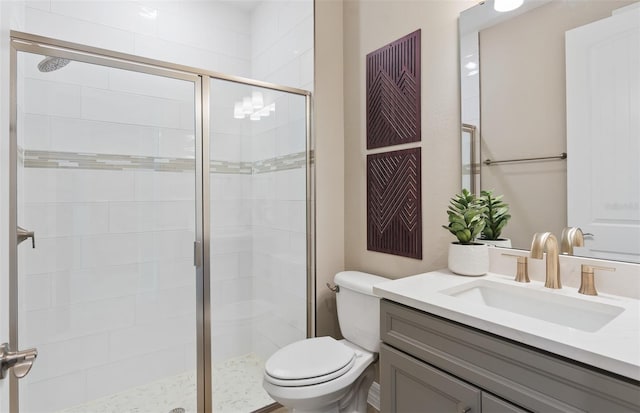 bathroom with vanity, a shower with shower door, and toilet